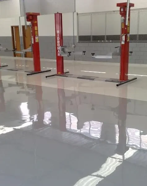 Piso de garagem residencial revestido com tinta epóxi cinza — acabamento liso e brilhante, fácil de limpar